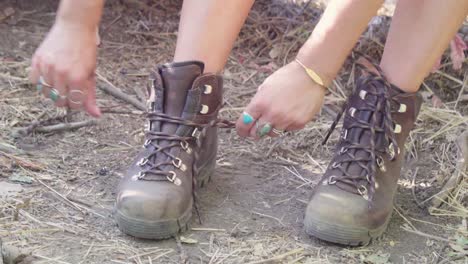 hipster girl tying her hiking boots on the park