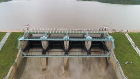 vista aérea de la liberación de agua de las puertas del embalse de la presa debido a la fuerte lluvia con aves volando alrededor - alerta de fuertes inundaciones debido a las fuertes lluvias en la india