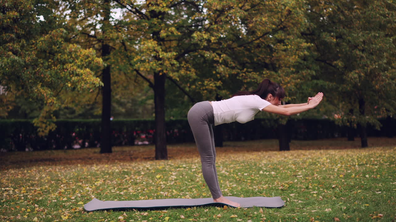 Woman practicing yoga in a park in the fall