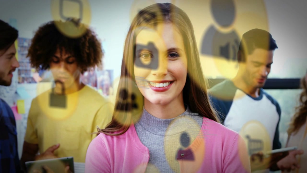 Mulher de cardigan rosa relaxando e sorrindo em um laboratório de tecnologia enquanto ícones de sobreposição aparecem e se movem.