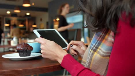 Pretty-brunette-having-a-coffee-in-cafe-using-tablet