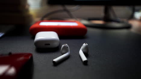 airpods stacked next to hard drive backups at editing desk