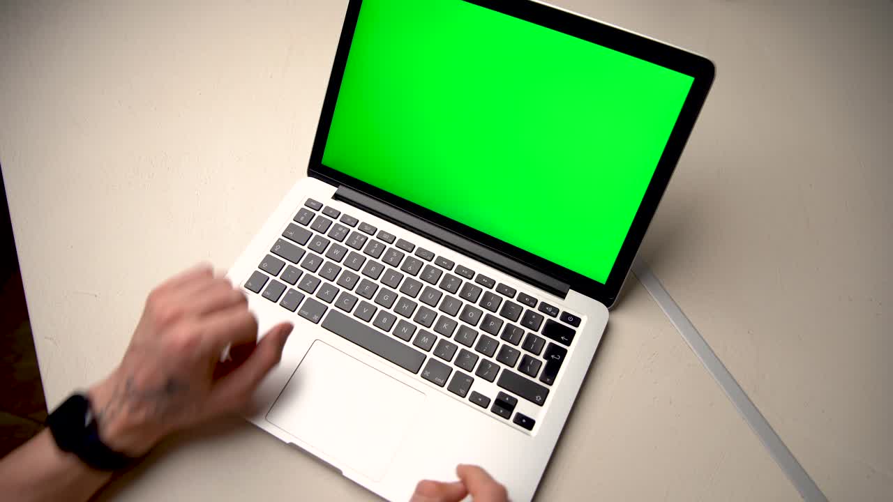 Uomo che usa un computer portatile con schermo Chroma key sulla scrivania a casa, video stock