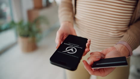 woman using a smartphone to make a payment with her credit card.