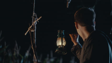man with a lantern in a dark field at night