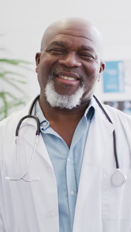 vertical video of portrait of happy african american male doctor