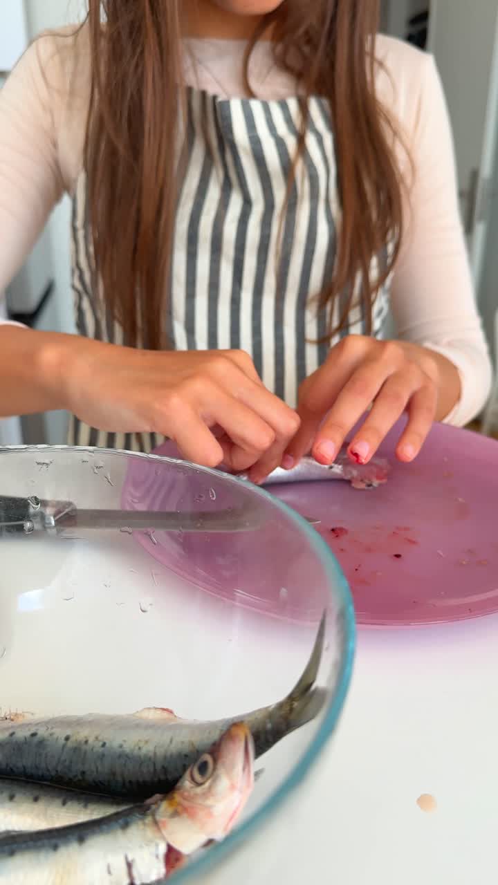 A person cleaning raw fish in a kitchen