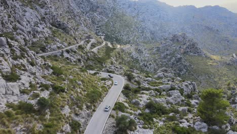 Kurzer-Drohnenclip-Eines-Autos,-Das-Eine-Windige-Straße-In-Den-Bergen-Von-Sa-Calobra,-Mallorca,-Spanien,-Hinunterfährt