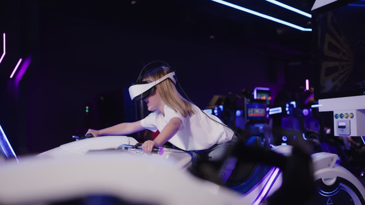 Child playing virtual reality motorcycle simulator game in an arcade