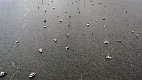foto aérea tomada por un avión no tripulado mirando hacia abajo y moviéndose hacia adelante a lo largo del estuario del río exe, mostrando barcos amarrados y agua brillante, en devon, reino unido