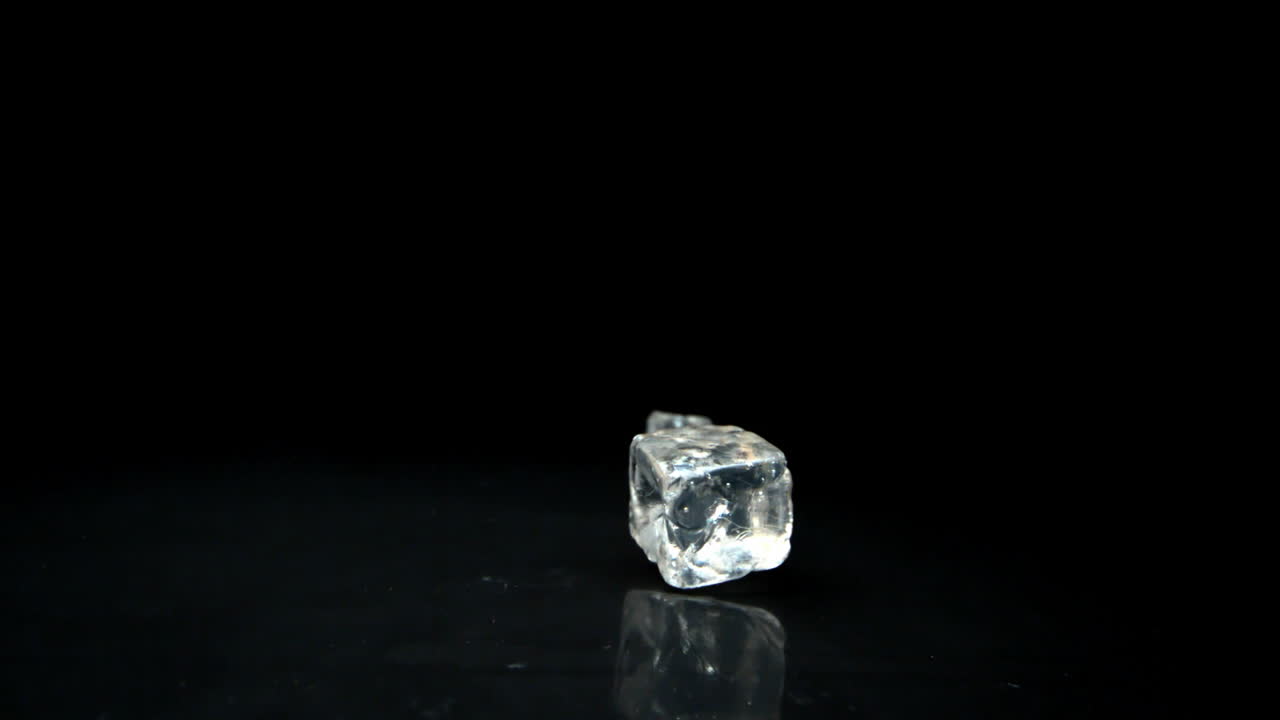 Due cubetti di ghiaccio che rotolano verso la telecamera