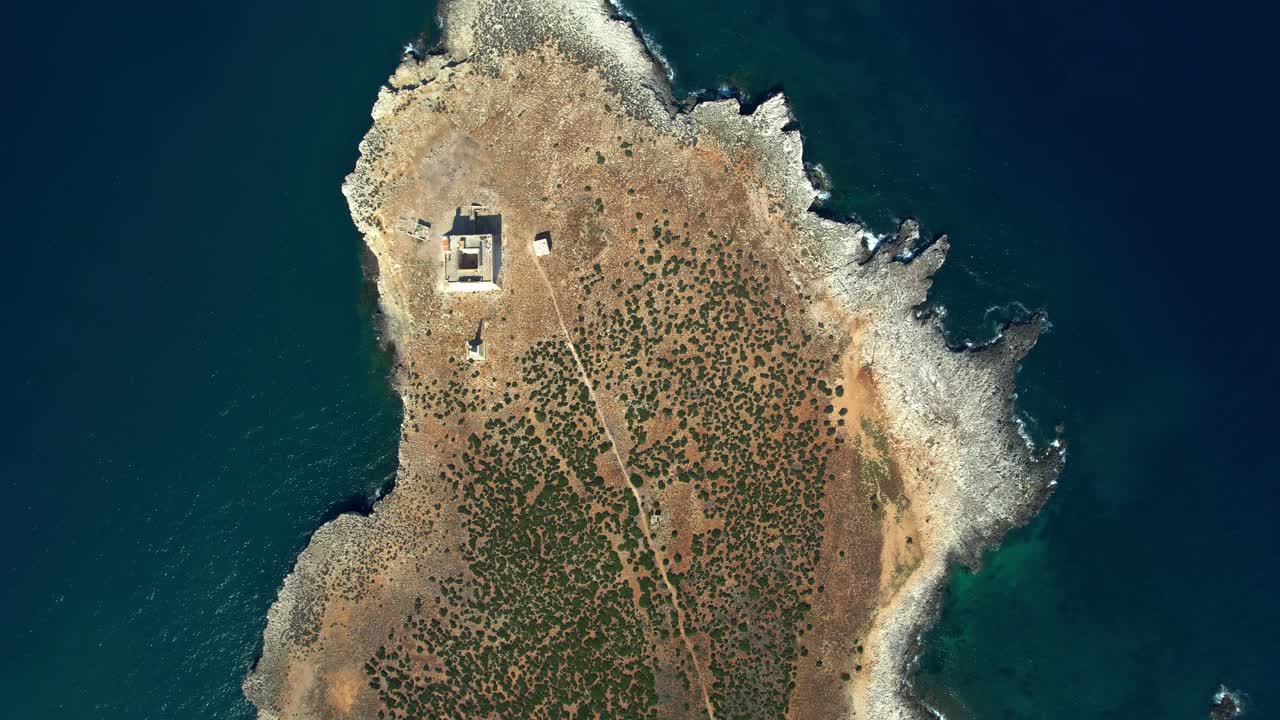 Top-down view of a Sicilian island with ancient ruins, surrounded by clear blue Mediterranean sea.