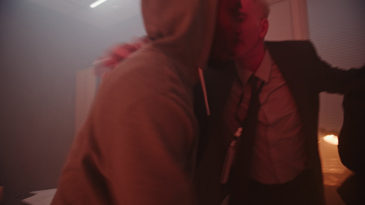 una pareja mirando por una ventana por la noche.