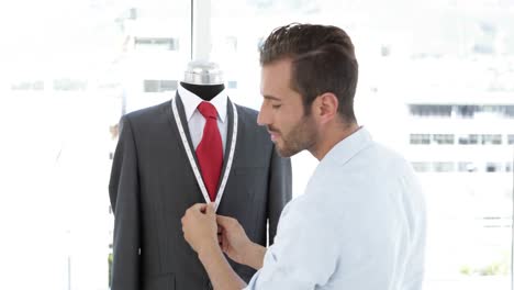 Handsome-tailor-measuring-suit-on-mannequin