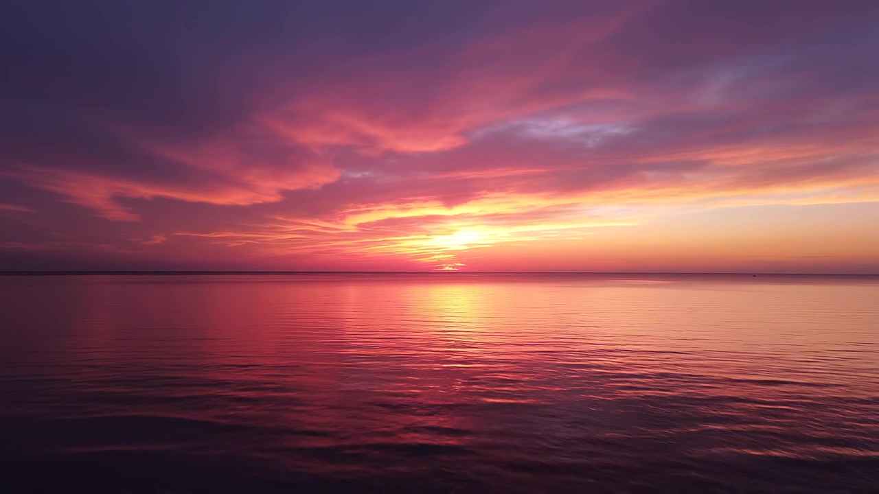Vibrant Sunset Reflection Over Calm Ocean Waters