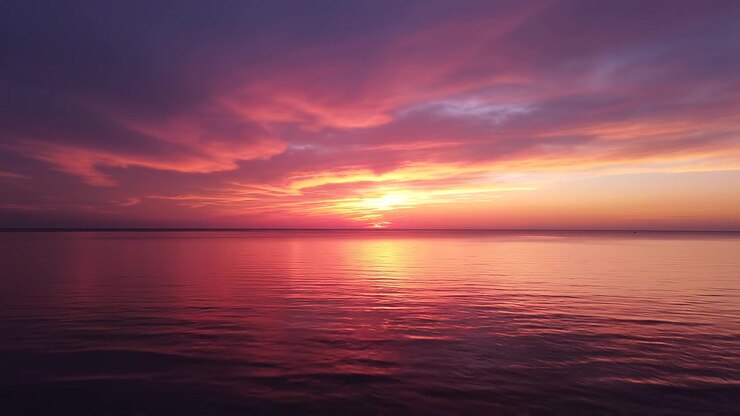Vibrant Sunset Reflection Over Calm Ocean Waters