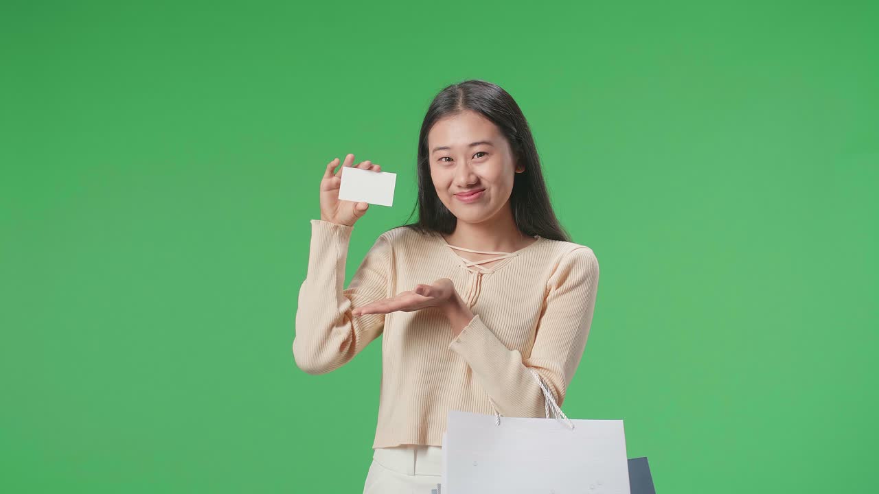 Woman presenting business card with shopping bags