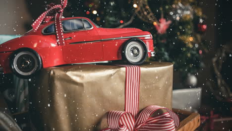 Red-model-car-and-a-christmas-present-combined-with-falling-snow