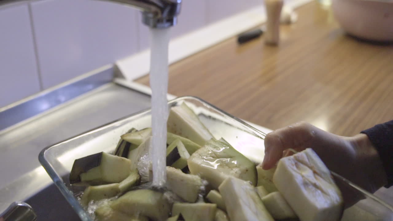 수돗물을 열고, 물로 음식을 씻고, 글루텐이 없는 완전 채식 음식으로 부엌에서 위생적으로 슬로우 모션 샷