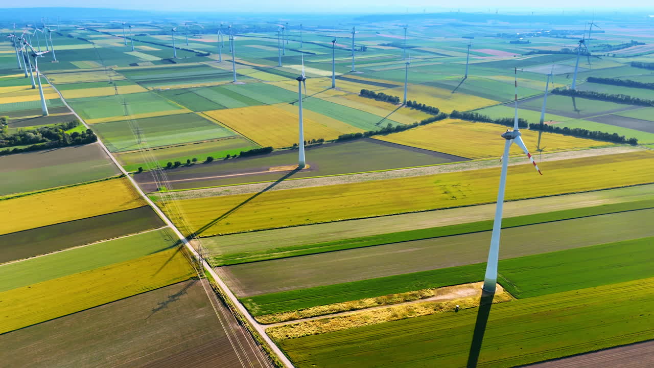 Wind turbines installed in the countryside. Aerial perspective on the agricultural fields with wind farms.
