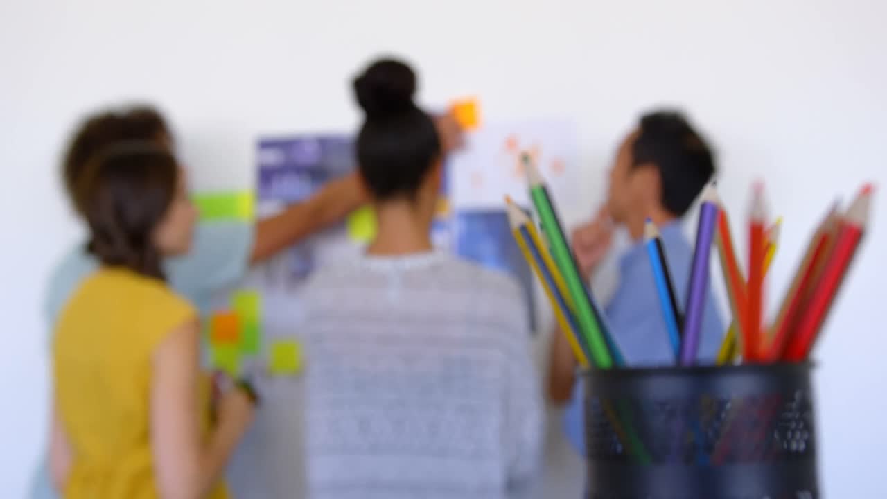 colegas de negocios multiétnicos discutiendo sobre gráficos y notas adhesivas en la oficina moderna 4k