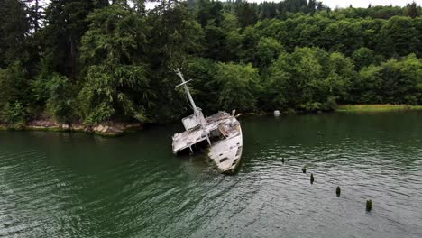 aerial zoom out of shipwreck of uss plainview military boat on columbia river coast