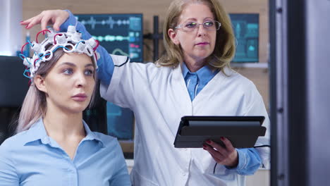 tomada de muñeco de una doctora comprobando los sensores de los auriculares del paciente