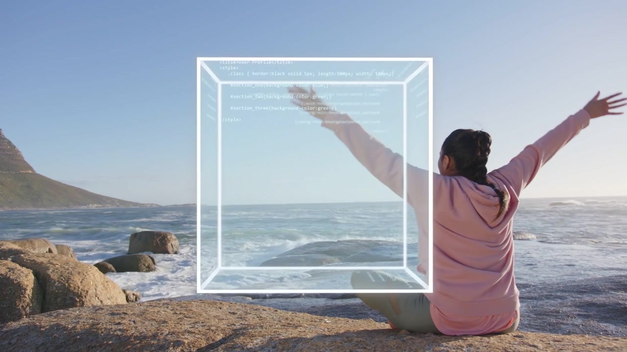 Donna seduta su una roccia vicino all'oceano, un cubo appare, facendole alzare il braccio, usando il cubo che mostra tecnologia di codice.