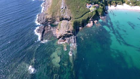 Drone-Shot-Revealing-Surgey-Cliff-Surrounded-by-Turquoise-Water-in-Sanxenxo