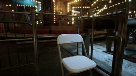 lonely chair in an empty amusement park at night under dim lights