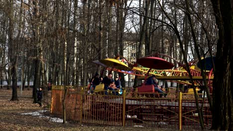 people ride on the rainbow ride at the amusement park in the spring in bobruisk, belarus 03.09.19. happy people spin on the colorful attraction at the amusement park in the open air.