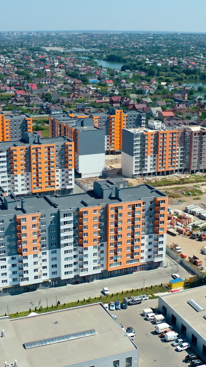 Beautiful residential complex. Modern infrastructure in the outskirts of a city. Construction of bright high-rise buildings of a new district. Aerial view. Vertical video