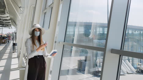 mujer en el aeropuerto con máscara y documentos