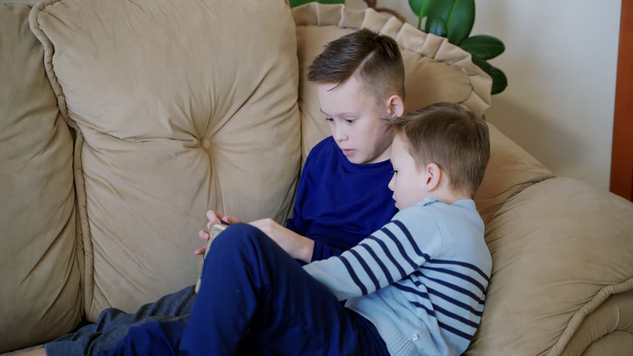 Preschool boys playing on smartphone. Peaceful pastime. Technology and lifestyle concept