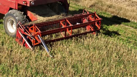 Wheat-harvest-Harvester-machine-close-up-harvesting-golden-ripe-wheat-field-on-an-agricultural-field-Agriculture-food-production