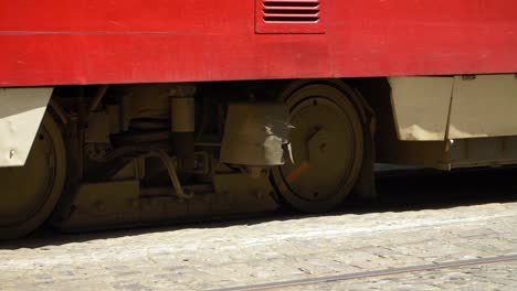 wheels of a red tram stopping