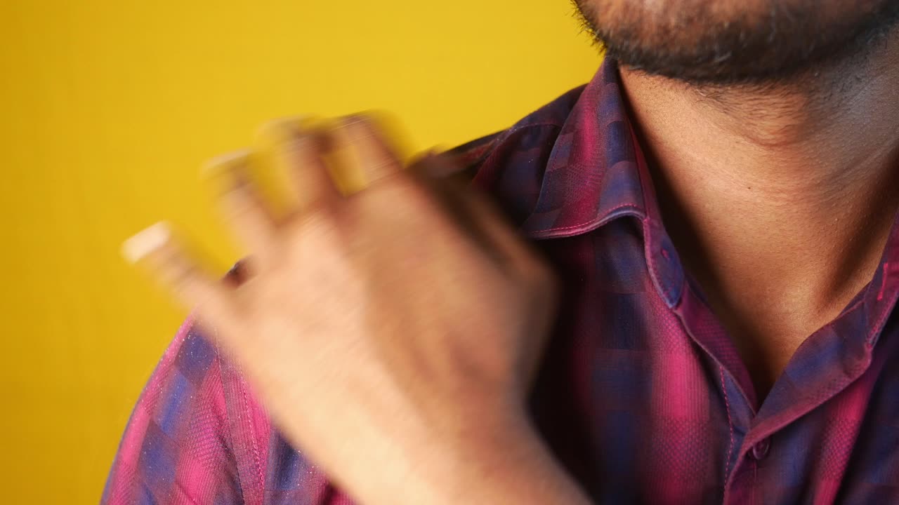 A close-up of a man's hand scratching his shoulder