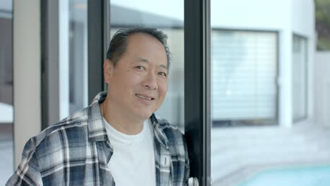 smiling man in casual outfit standing by glass door, enjoying vacation