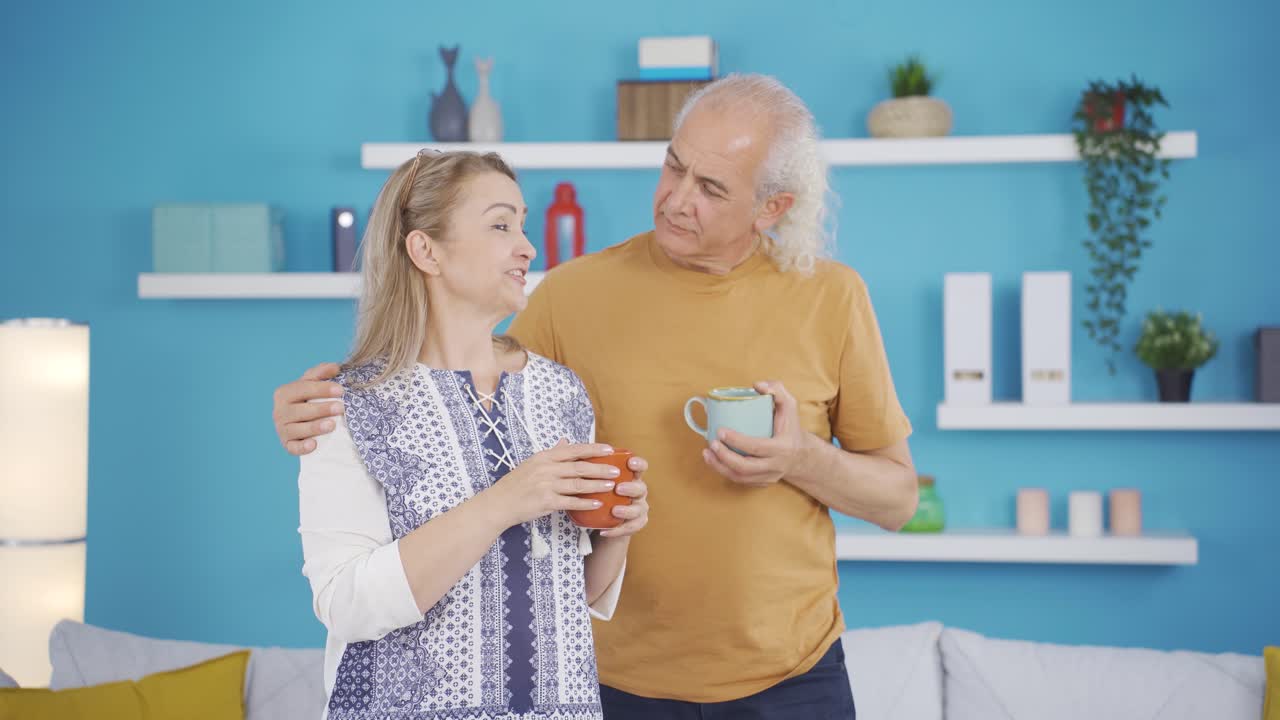 행복한 커플이 집에서 커피를 즐기고 있습니다.