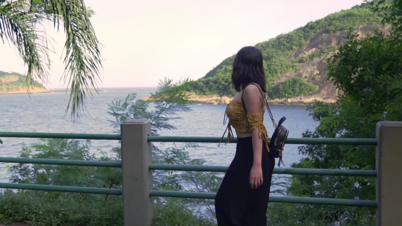 Asian girl looking out to sea near the sugarloaf mountain and Copacabana beach in Rio de Janeiro