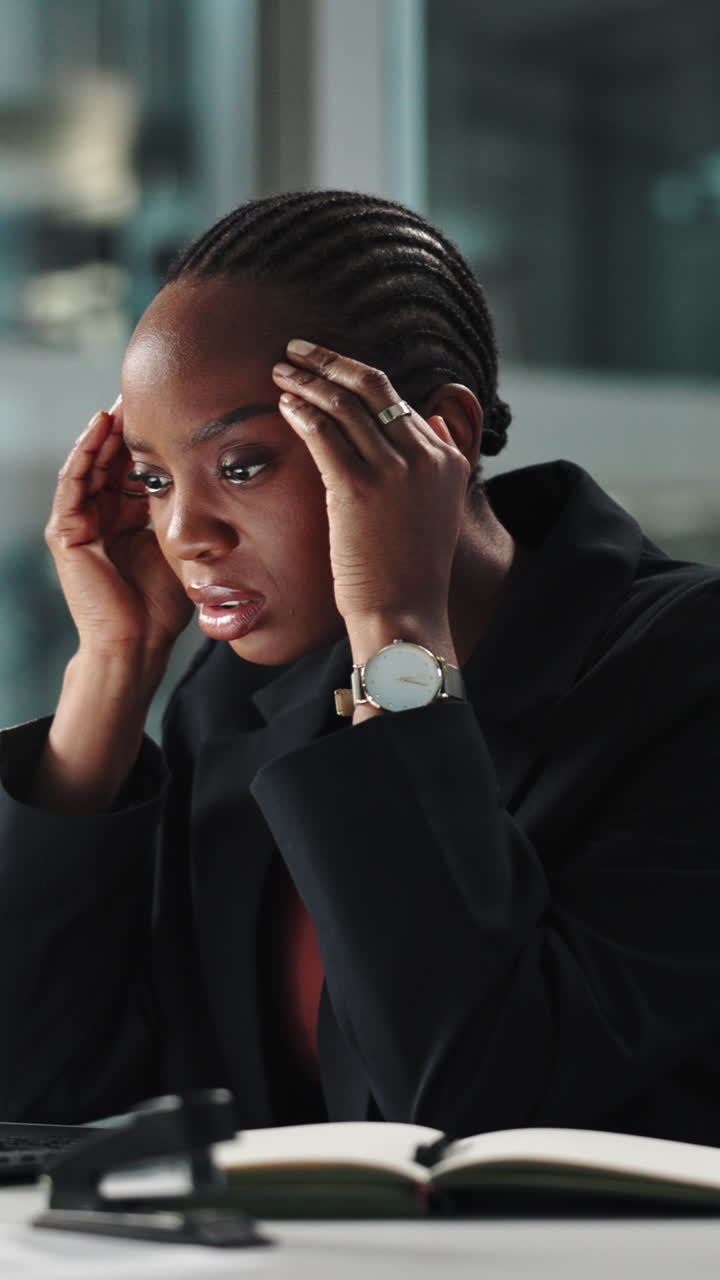 Stressed Black Businesswoman Rubbing Temples in Office