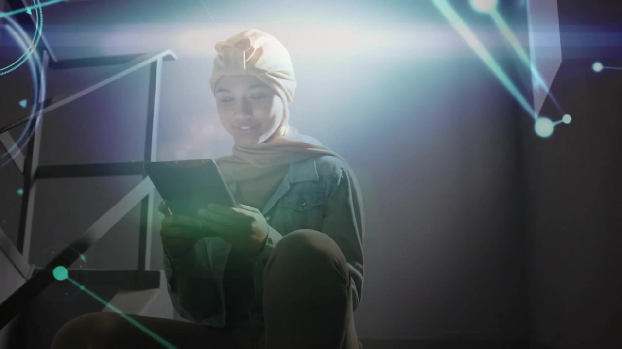 Woman placing tablet on lap and scrolling in tech workspace network graphics pulsing around focus