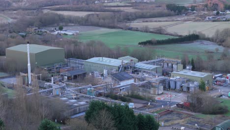 aerial video footage of industrial buildings and housing. terraced streets in textile towns at sunset. chemical plant surrounded by red brick homes with busy streets. yorkshire living concept