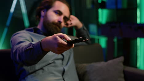 primer plano del control remoto utilizado por un hombre aburrido zapping a través de canales de televisión