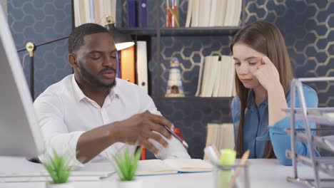 motivated young black businessman explaining company development strategy to diverse young colleague.