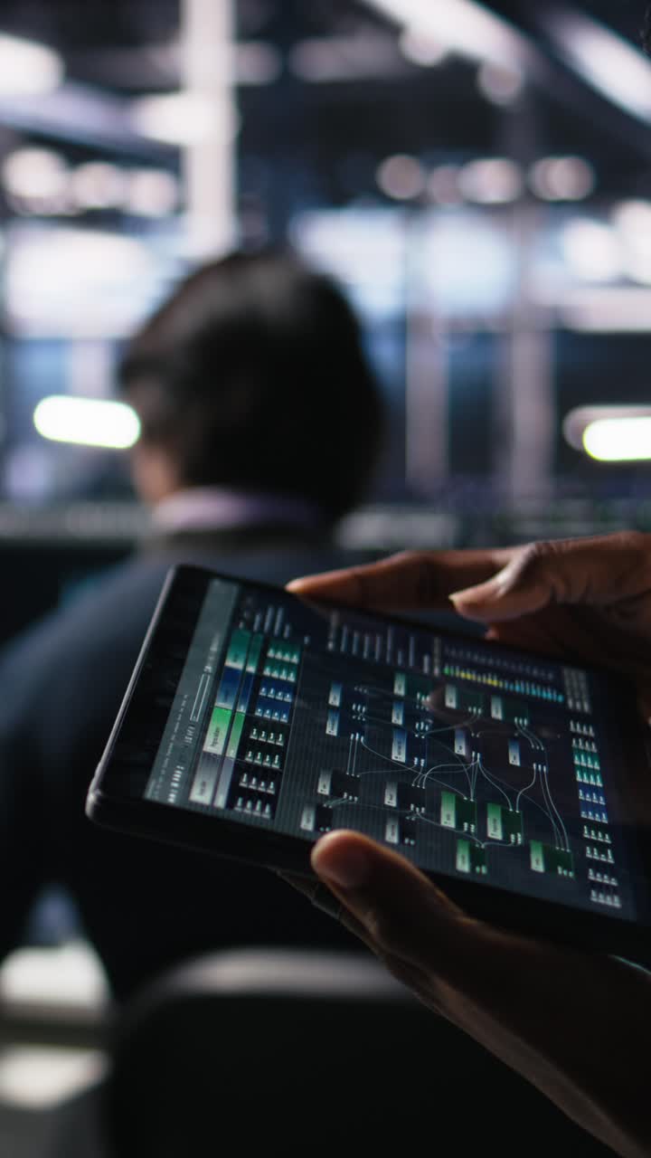 Vertical video Close up of data center engineer using tablet to review code