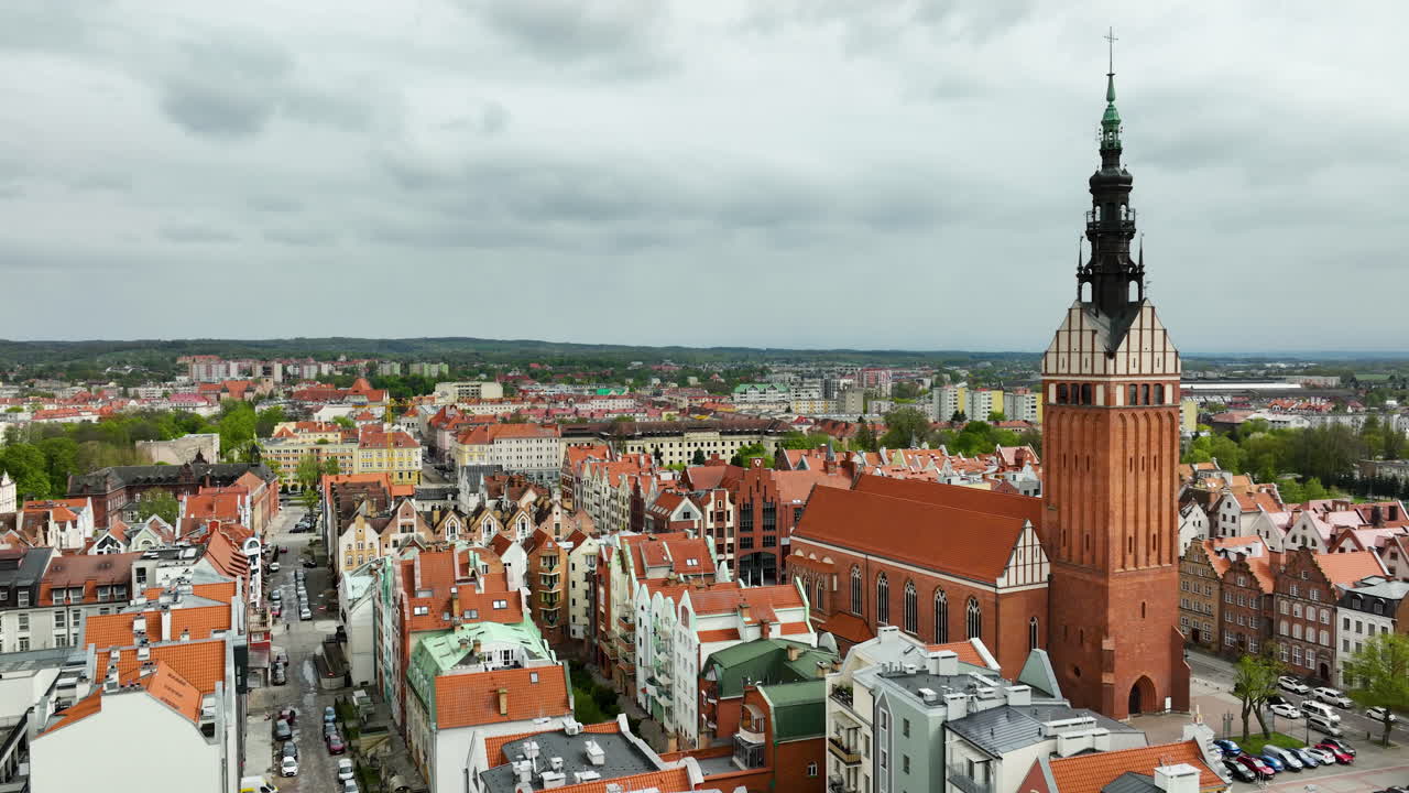 vista aérea de la histórica catedral de elbląg que se eleva sobre el casco antiguo, con un tapiz de techos de terracota que se extiende en el paisaje urbano moderno