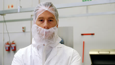 Butcher-standing-in-meat-shop-with-his-arms-crossed