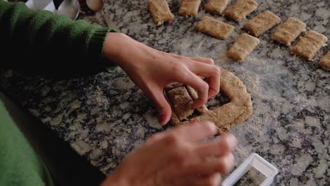 high angle shot woman hands cutting cookies placing them on countertable