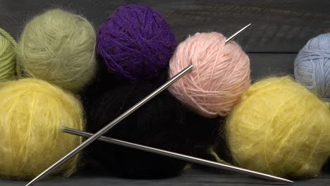 balls of yarn for knitting lie on a wooden board